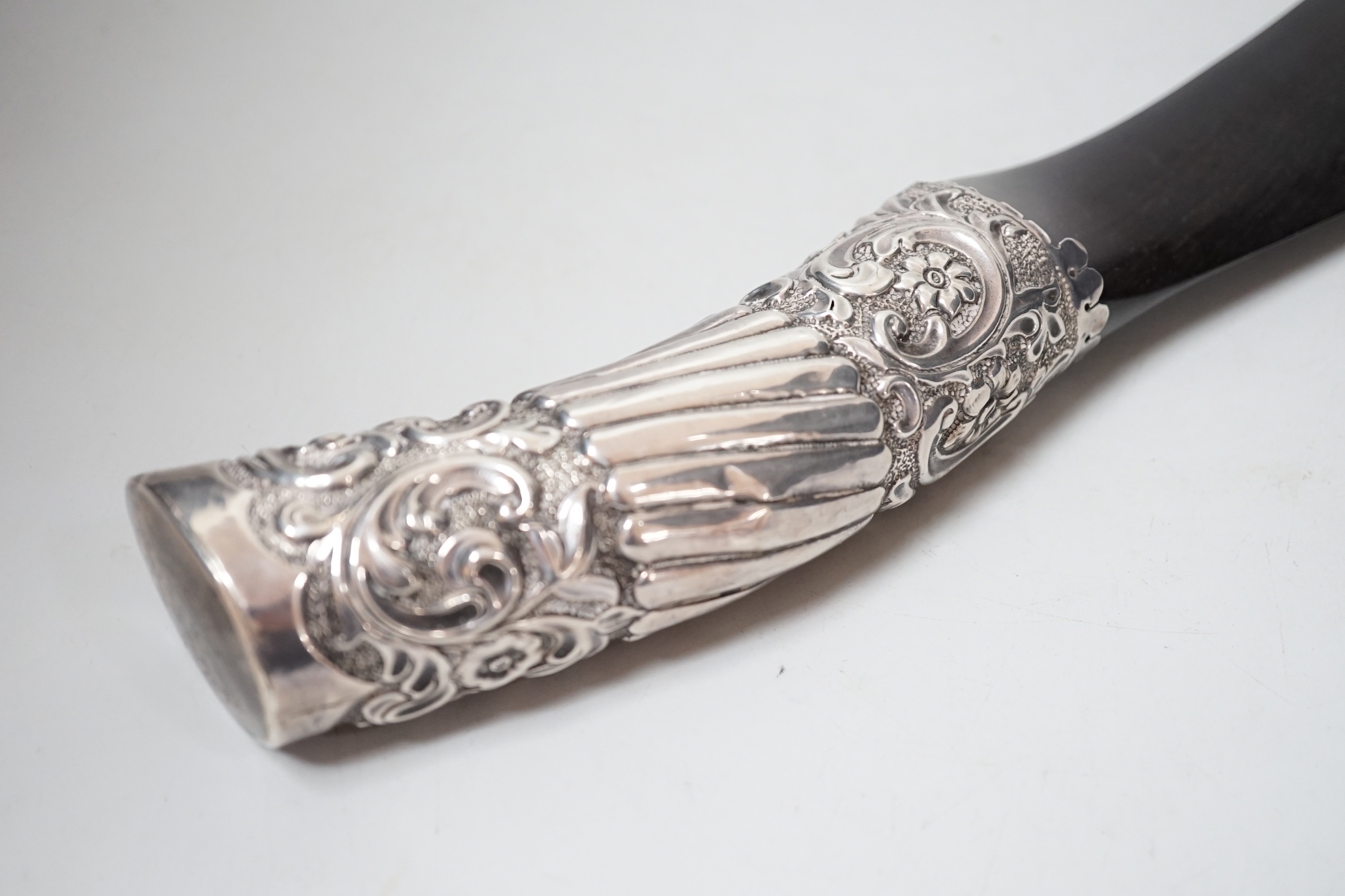 A Victorian repoouse silver handled ebony 'scimitar' page turner, Rosenthal, Jacob & Co, London, 1889, 48.9cm.